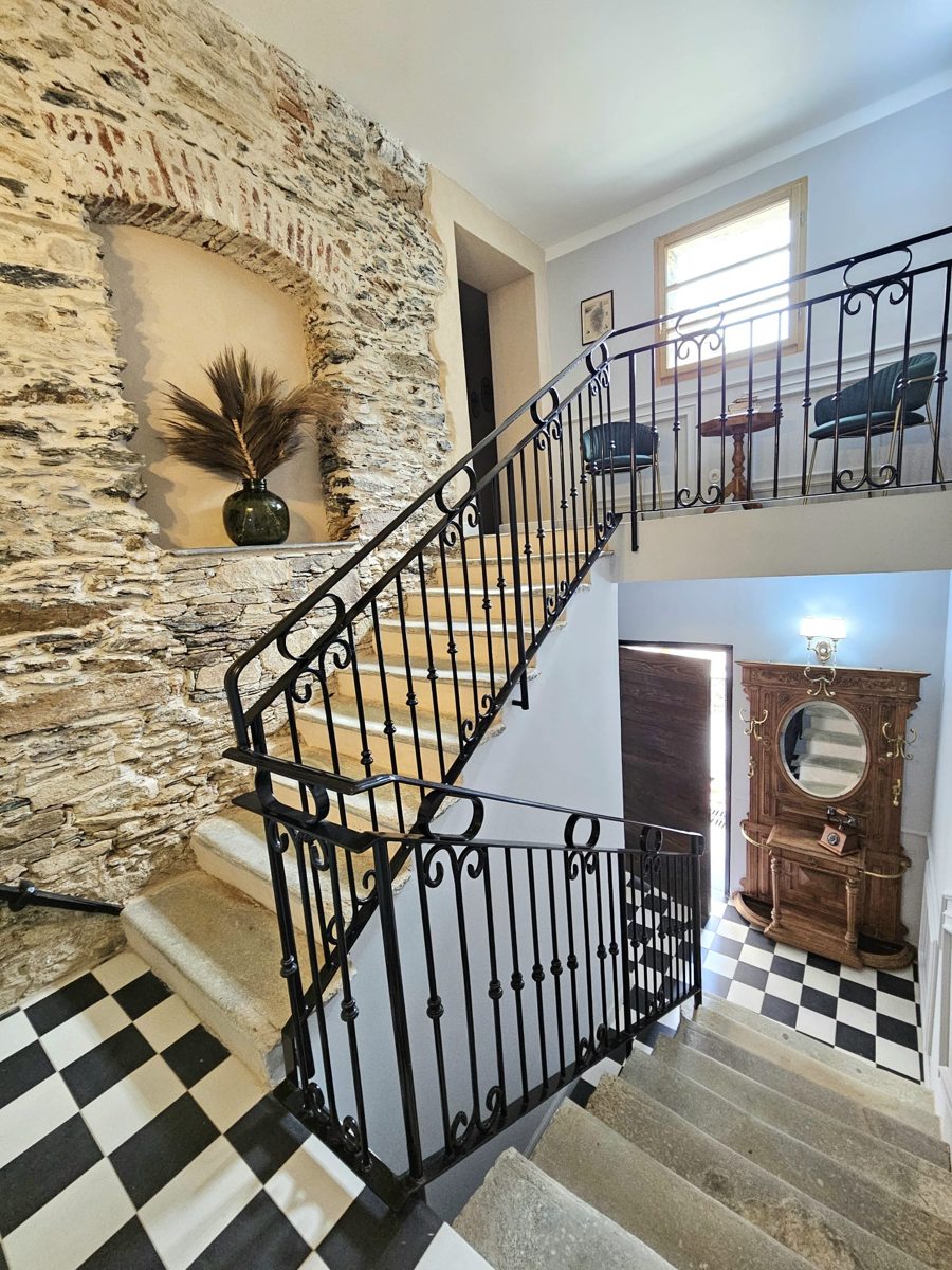 Escalier avec rampe de fer forgé, maison de pierre